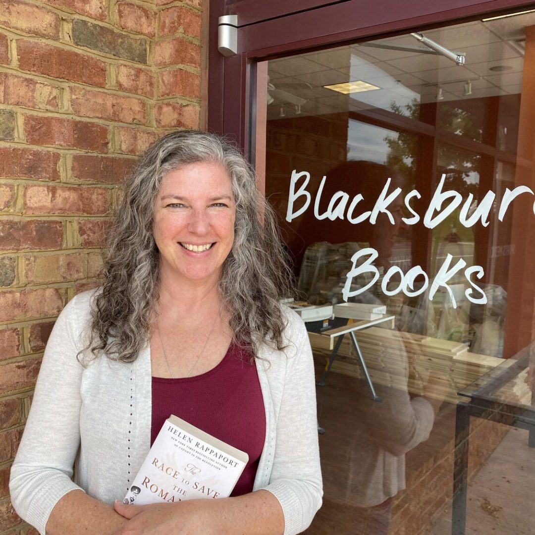 Woman holding book outside Blacksburg Books store.